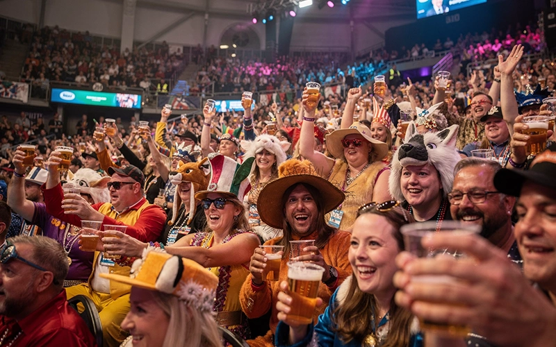Volle tribune met verklede dartsfans in Alexandra Palace